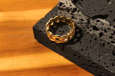 Decorative podium with beautiful ring on wooden background