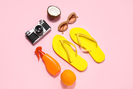 Beach accessories with photo camera and fruits on pink backgroundの写真素材