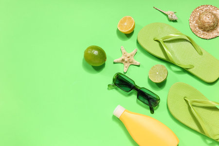 Beach accessories with starfish and fruits on green backgroundの写真素材