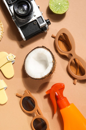 Beach accessories with fruits on beige background