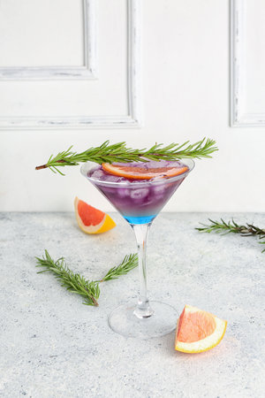 Glass of purple gin and tonic with grapefruit on light tableの写真素材