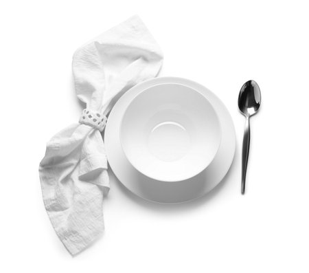 Simple table setting with bowl, spoon and napkin on white backgroundの写真素材