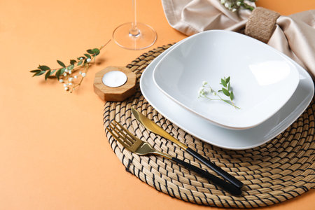 Beautiful table setting with candle and gypsophila flowers on beige background, closeup