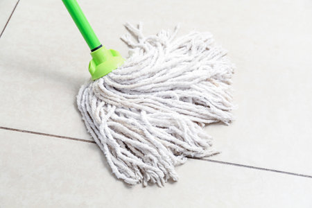 Mop on light tile floor, closeupの写真素材