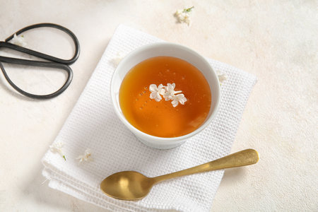 Beautiful lilac flowers with cup of tea and scissors on white grunge backgroundの写真素材