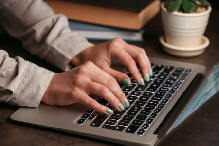 Woman working with modern laptop on brown tableの写真素材