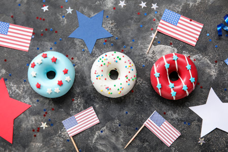 Composition with donuts, USA flags and confetti on black grunge table. independence day celebrationの写真素材