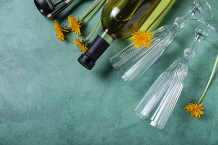 Bottle and glasses of dandelion wine on green backgroundの写真素材