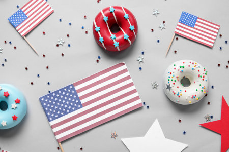 Composition with donuts, USA flags and confetti on gray background. independence day celebrationの写真素材