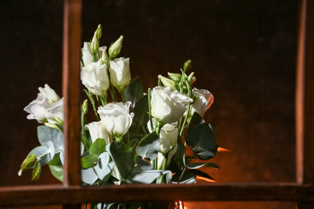 Vase with beautiful eustoma flowers on windowsill, view through windowの写真素材