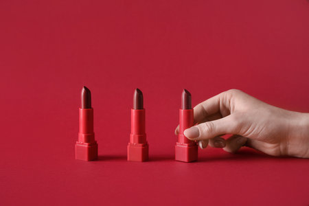 Woman with lipsticks on red backgroundの写真素材