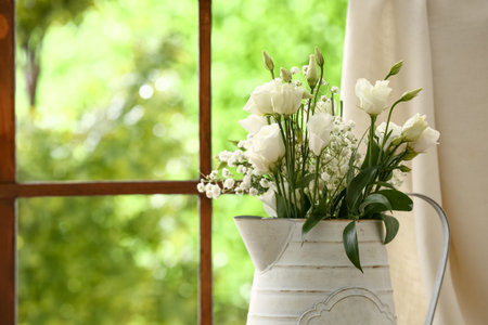 Vase with beautiful eustoma and gypsophila flowers near window