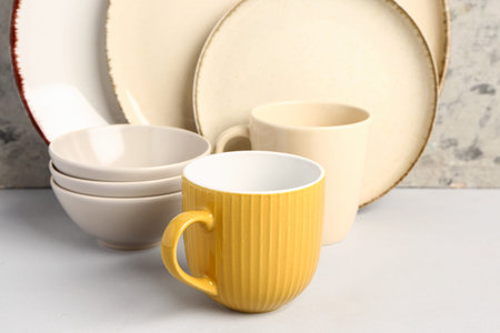 Set of different dishes on table near gray grunge wall