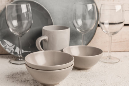 Set of different dishes on table near beige wooden wall