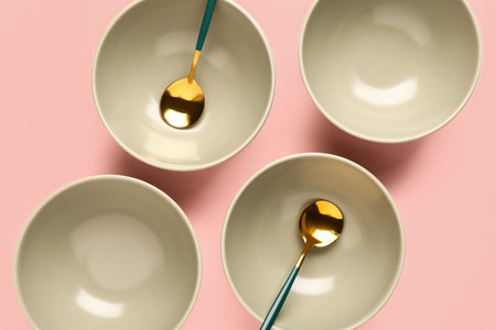 Composition with clean bowls and spoons on pink backgroundの写真素材