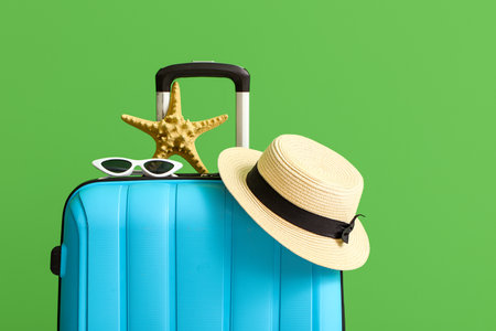 Suitcase with hat, sunglasses and starfish on green backgroundの写真素材