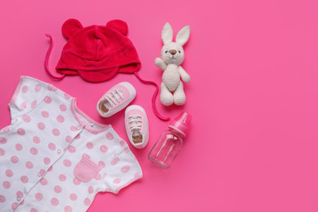 Composition with baby clothes, toy and bottle on pink backgroundの写真素材