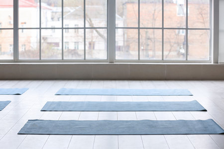 Yoga mats on floor near window in gymの写真素材