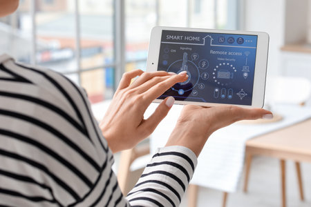 Young woman using smart home security system control panel in kitchen, closeupの写真素材