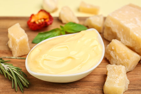 Board with creamy pizza sauce and ingredients on beige background, closeupの写真素材