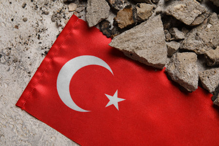 Turkish flag with stone debris on grunge background, closeup. Turkey earthquake conceptの写真素材