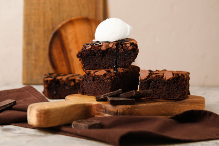 Wooden board with pieces of tasty chocolate brownie and ice cream on tableの写真素材