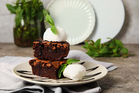 Plate with pieces of tasty chocolate brownie and ice cream on tableの写真素材