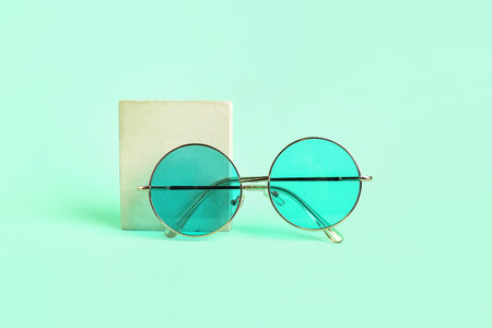 Stylish sunglasses with podium on mint backgroundの写真素材