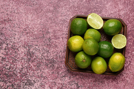 Tray with fresh limes on purple backgroundの写真素材