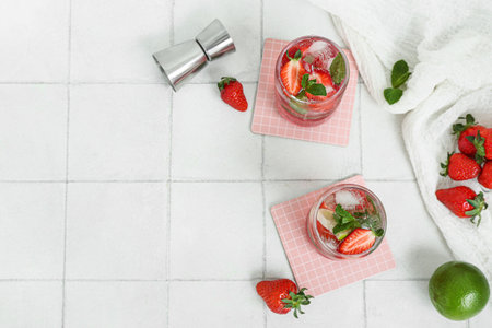 Glasses of fresh strawberry mojito on light tile backgroundの写真素材