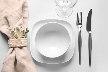 Beautiful table setting and gypsophila flowers on white background