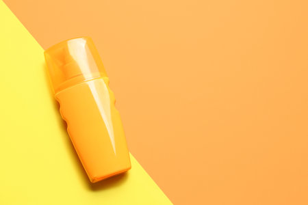 Bottle of sunscreen cream on color backgroundの写真素材