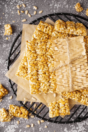 Stand with tasty kozinaki in parchment on grunge gray backgroundの写真素材