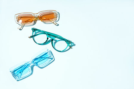 Stylish different sunglasses on pale blue backgroundの写真素材