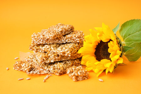 Sunflower with tasty kozinaki and seeds on orange backgroundの写真素材