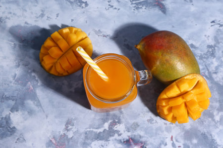 Mason jar of fresh mango smoothie on blue backgroundの写真素材