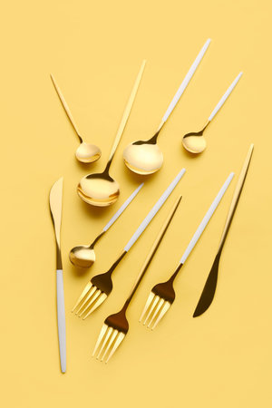 Stylish cutlery on yellow background