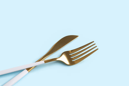 Stylish fork and knife on blue backgroundの写真素材