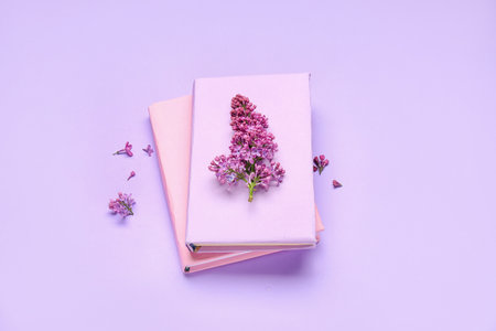 Lilac twig on notebooks on color backgroundの写真素材