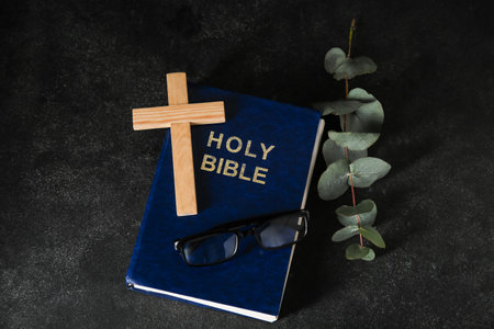 Holy Bible with eyeglasses and wooden cross on black backgroundの写真素材