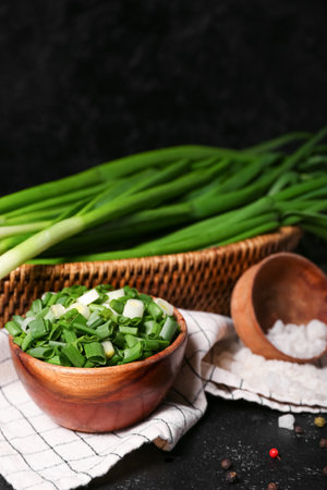 Bowl with fresh cut green onion on dark backgroundの写真素材