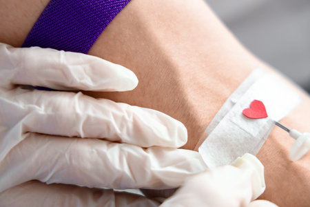 Doctor taking blood from male donor in clinic, closeup