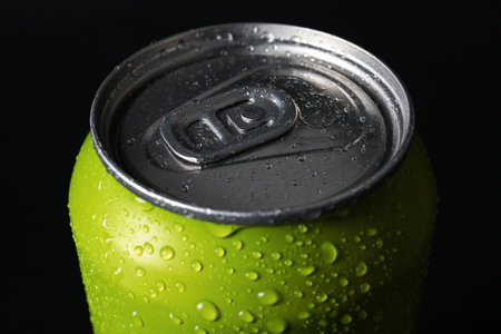 Green can of fresh soda with water drops on dark background, closeupの写真素材