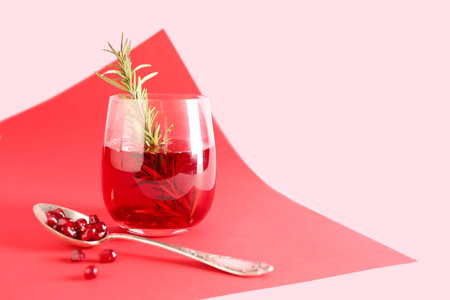 Spoon with fresh pomegranate and glass of juice on colorful background