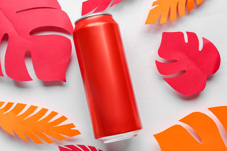 Composition with can of fresh soda and paper leaves on gray backgroundの写真素材