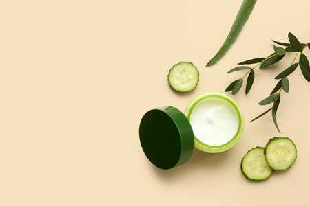 Jar of natural cream, cucumber slices and eucalyptus branch on color backgroundの写真素材