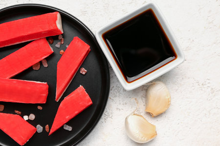 Plate with tasty crab sticks and sauce on light background, closeupの写真素材