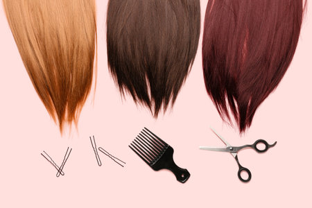 Beautiful hair with pins, brush and scissors on pink backgroundの写真素材