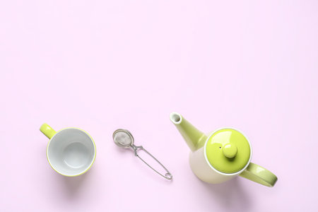 Teapot, mug and infuser on lilac backgroundの写真素材