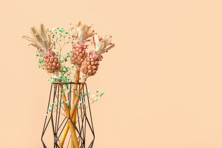 Vase with decorative pineapples on beige background, closeup